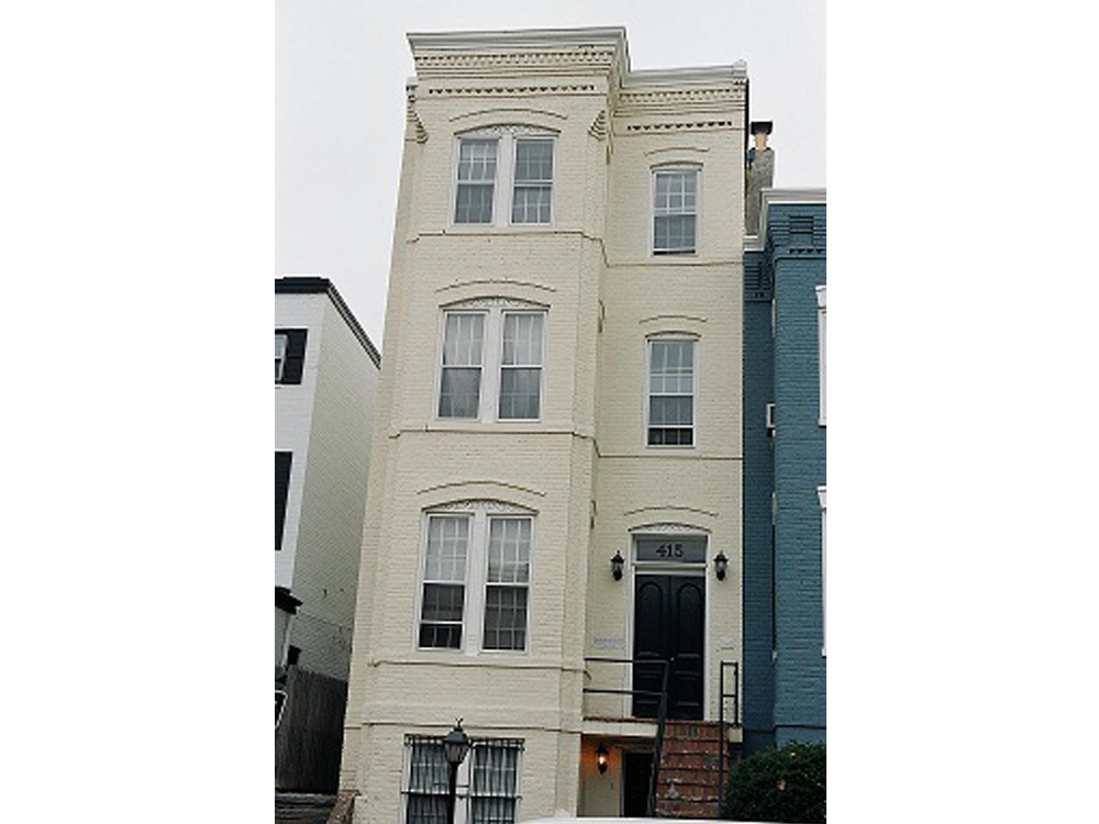 a white building with a black door and windows